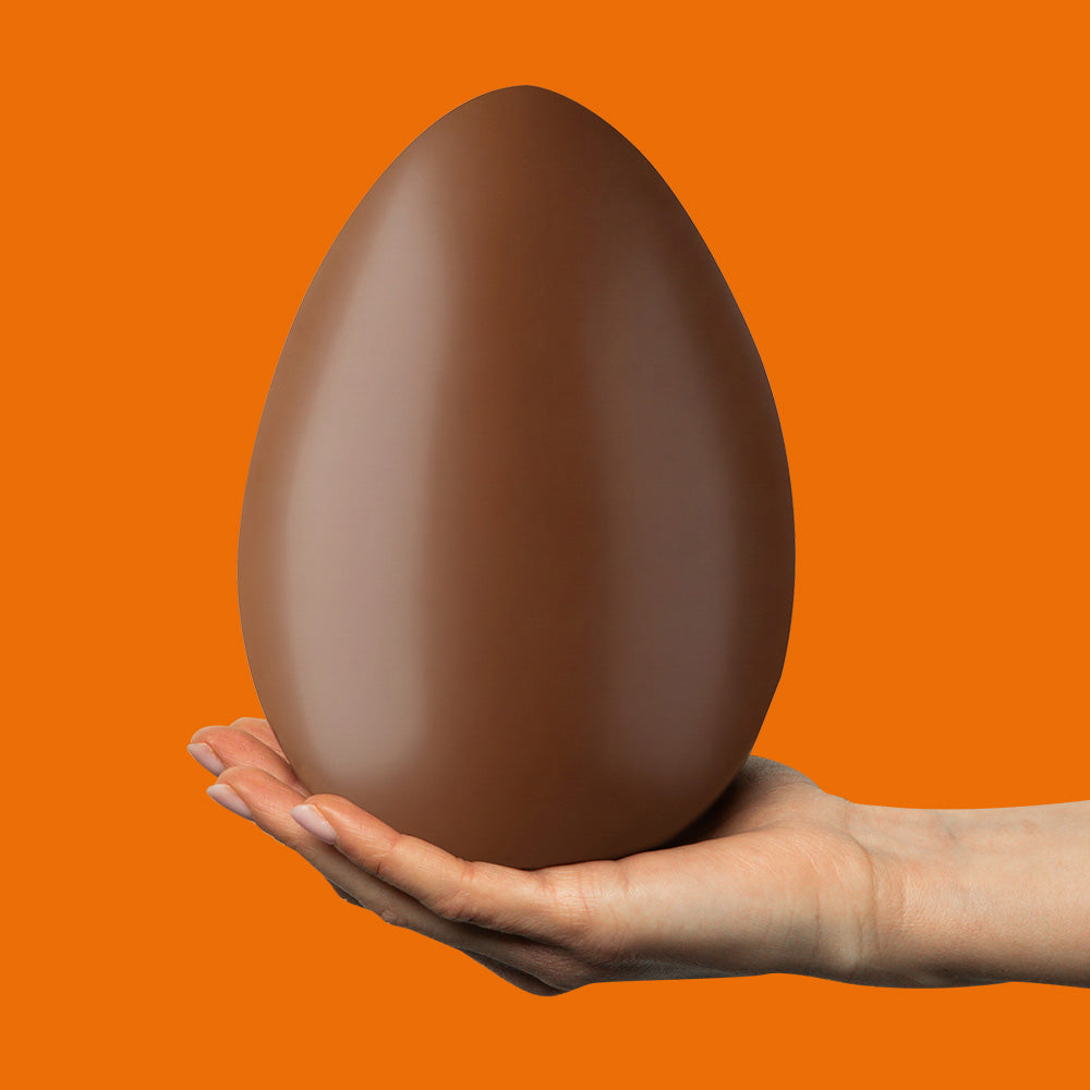 Uovo di cioccolato ripieno di burro d'arachidi sulla mano 